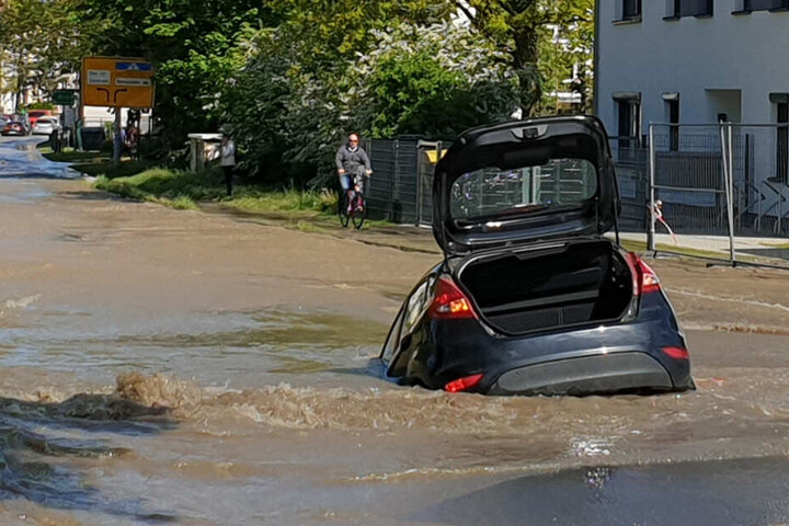 Das Auto steckt bis zur Hälfte im Loch.