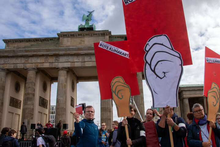 Während Politiker verhandeln, demonstrieren Tausende vor dem Brandenburger Tor.