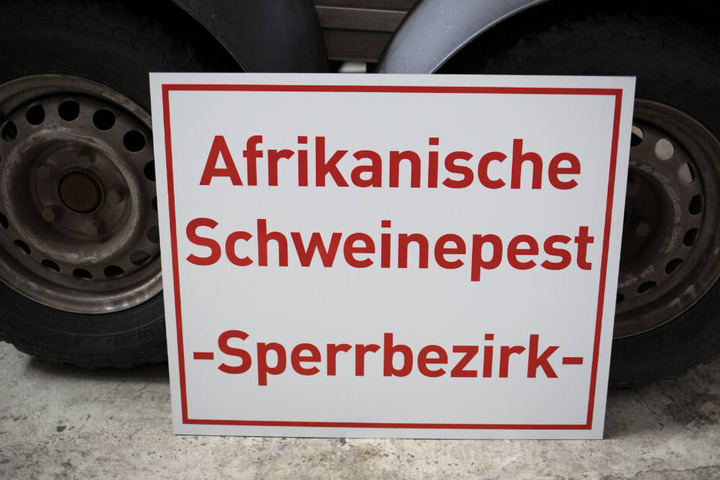 Ein Schild mit der Aufschrift "Afrikanische Schweinepest - Sperrbezirk-" steht bei einem Rundgang durch das hessische Zentrallager für Tierseuchenbekämpfungsmaterial an einen Anhänger gelehnt.