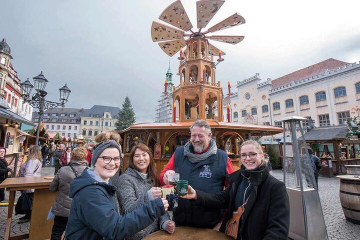 Ralf Schwartz (57), Chef der Glühweinpyramide, begrüßt die ersten Gäste auf dem Weihnachtsmarkt: Tina Kratzsch (23), Linh Nguyen (25) und Sarah-Marie Reichardt (22, von links) aus Thüringen.