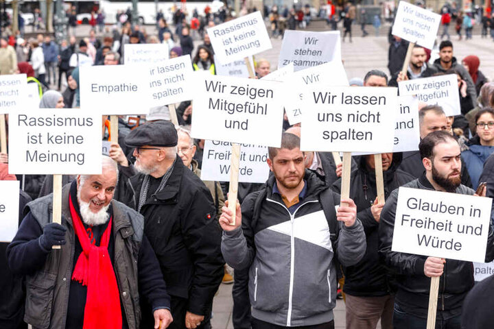 Demonstranten halten auf einer Friedenskundgebung für die Christchurch- Opfer Schilder mit Aufschriften wie "Wir lassen uns nicht spalten", "Wir zeigen Mitgefühl" und "Rassismus ist keine Meinung".