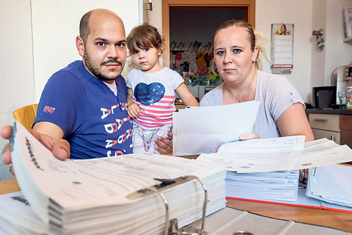 Thilo Hahn (38), Tochter Leila (2) und Mama Nicole Hahn (33) sitzen vor riesigen Aktenbergen.