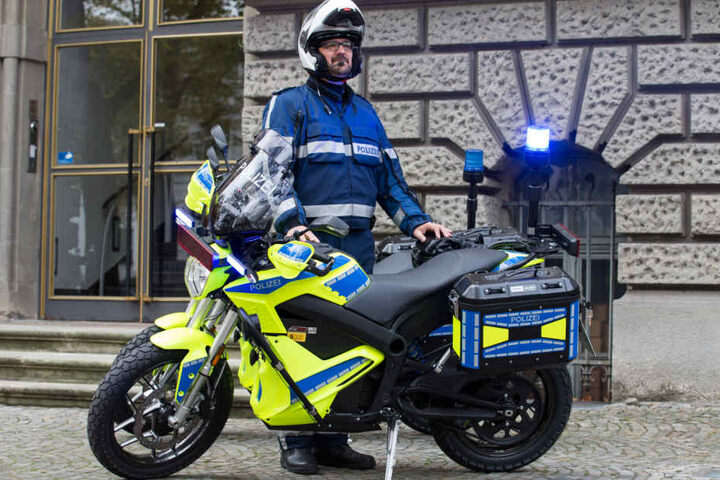 Polizeioberkommissar Björn Steven Sorge steht neben einem der beiden bundesweit ersten Elektro-Polizeimotorräder für den städtischen Einsatz- und Streifendienst.