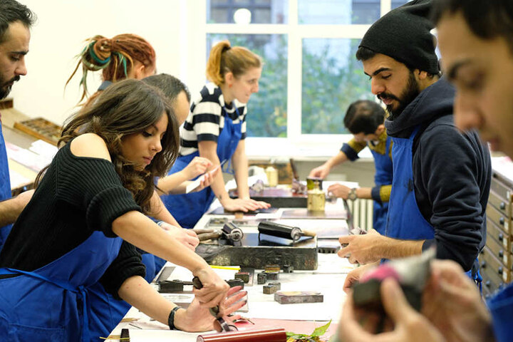 Studenten der HGB, darunter auch Flüchtlinge,
arbeiten in der Druckwerkstatt.
