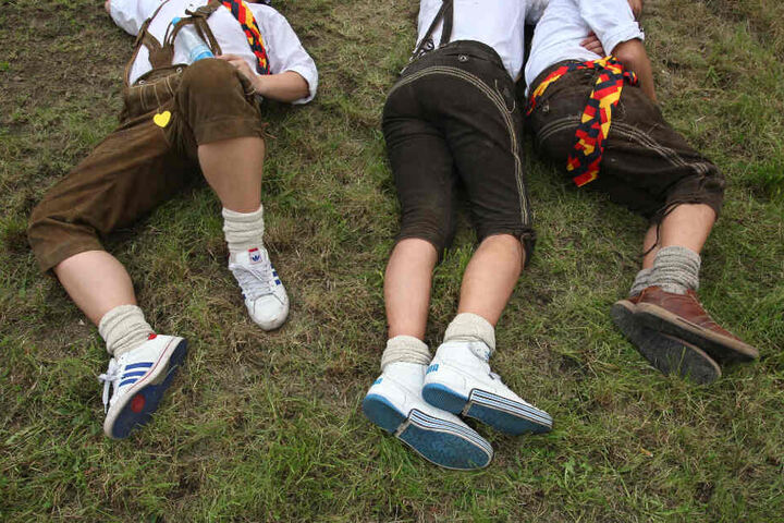 Lederhose, Turnschuhe und jede Menge Promille: Drei junge Männer schlafen auf dem Oktoberfest ihren Rausch aus.