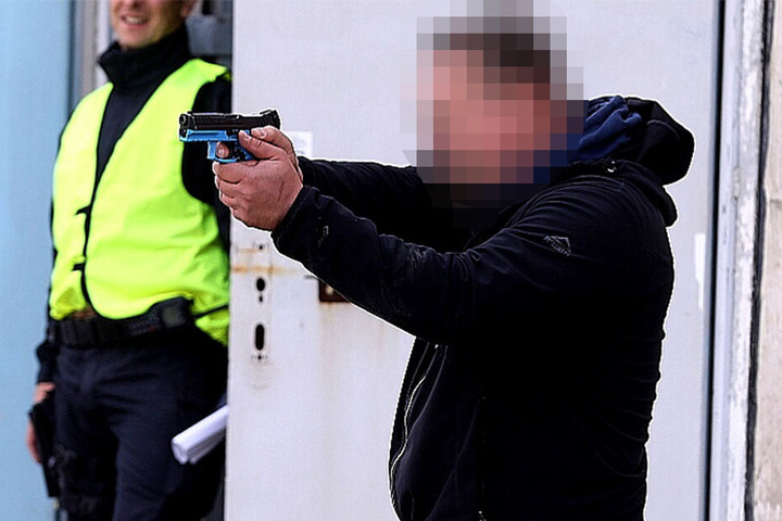 Ein lächelnder Mann im Hintergrund verrät es: Hier herrscht keine echte Bedrohung.