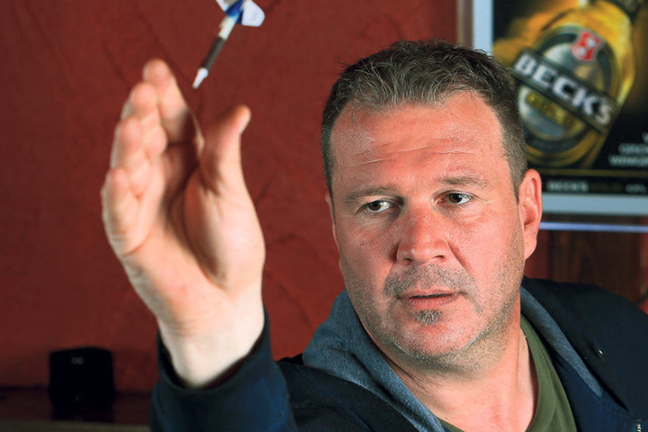 Kersten Müller (50) konzentriert sich auf die Dartscheibe und wirft den Pfeil.