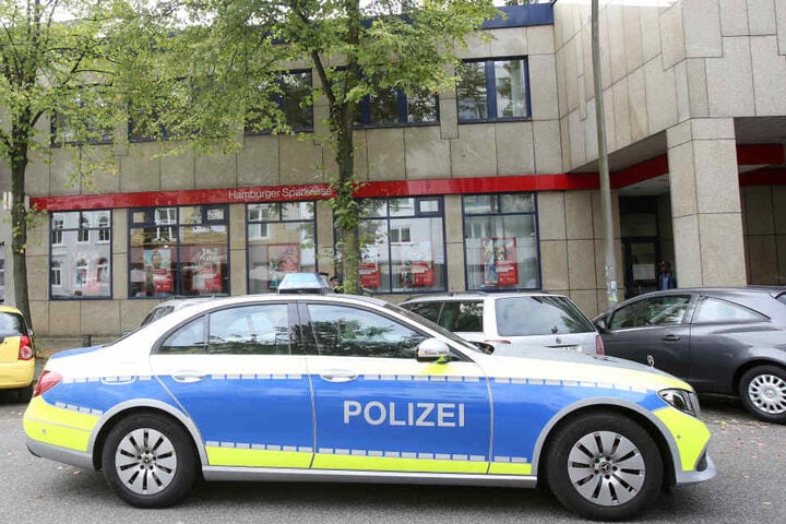 Ein Polizeiwagen steht nach einem Banküberfall an der Rückseite der Filiale.