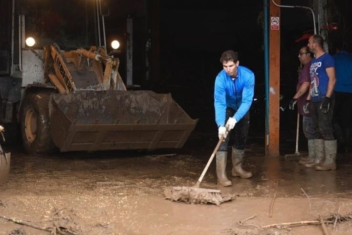 Der spanische Tennisspieler Rafael Nadal räumt mit den Bewohnern den Schlamm aus ihren Häusern.