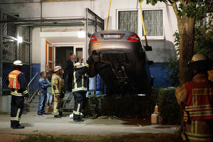 Die Anwohner des Hauses schauten gemeinsam mit den Einsatzkräften dabei zu, wie das Auto geborgen wurde.
