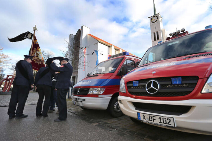 Angehörige der Feuerwehr stehen vor Beginn der Trauerfeier für einen getöteten Feuerwehrmann vor der Pfarrkirche St. Ägidius.