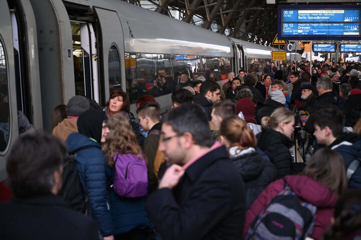 Bahnreisende versuchen im Kölner Hauptbahnhof nach dem Wiederanlauf des Bahnverkehrs einen der ersten Züge zu nehmen.