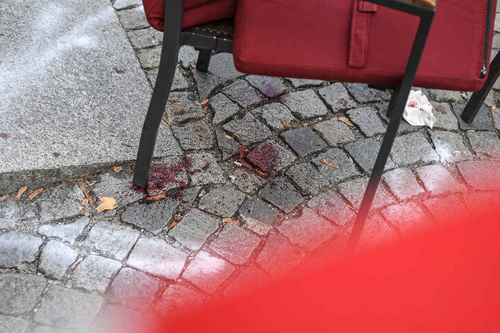 Der Bereich um einen Stuhl ist im abgesperrten Tatort auf dem Marienplatz markiert. Darunter ist Blut von der Messerstecherei zu sehen.