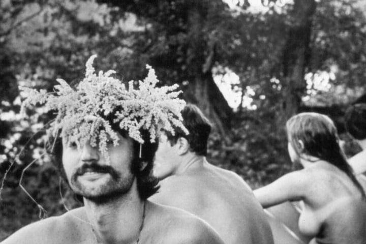 Einige unbekleidete Besucher sitzen im August 1969 beim Musikfestival Woodstock in Bethel.