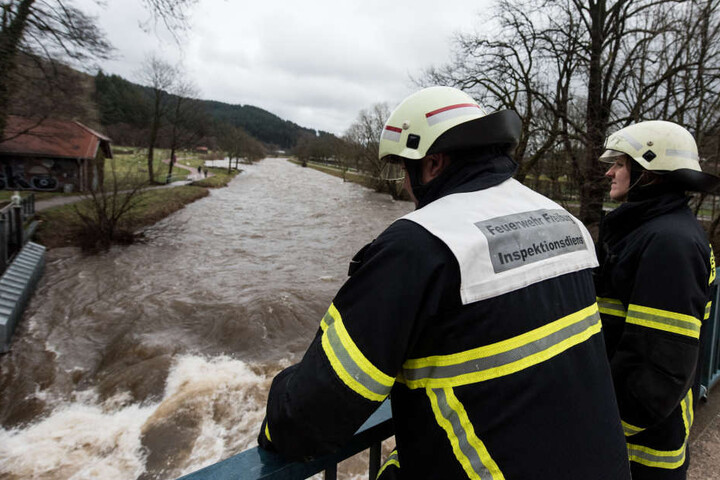 Feuerwehrleute kontrolliert in Freiburg die Dreisam bei Hochwasser.