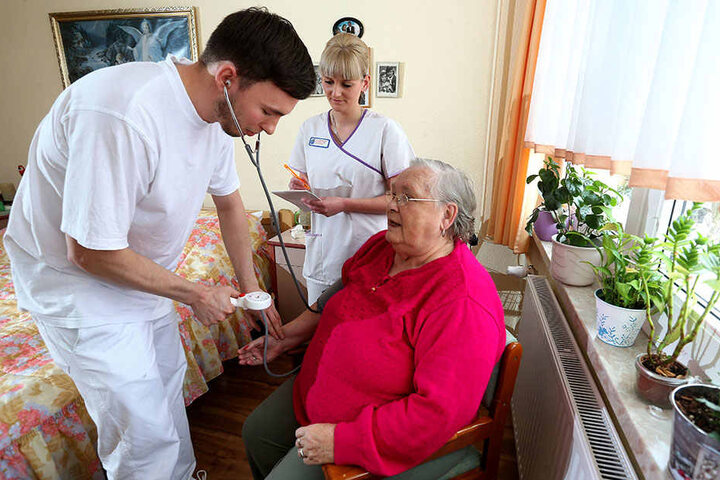 Azubi Christoph Golla (26) untersucht Patientin Gisela Hanke (79). Er wird von Caroline Winter angelernt.
