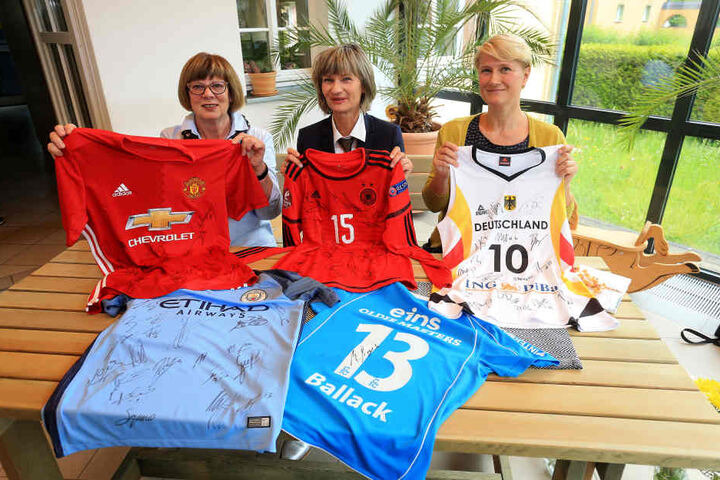Oberbürgermeisterin Barbara Ludwig versteigert auf eBay fünf Trikots. Der Erlös geht an Inge Oehme (F.l.) vom Elternverein krebskranker Kinder und Tina Kießling von der KiSS-Kindersportschule (F.r.)