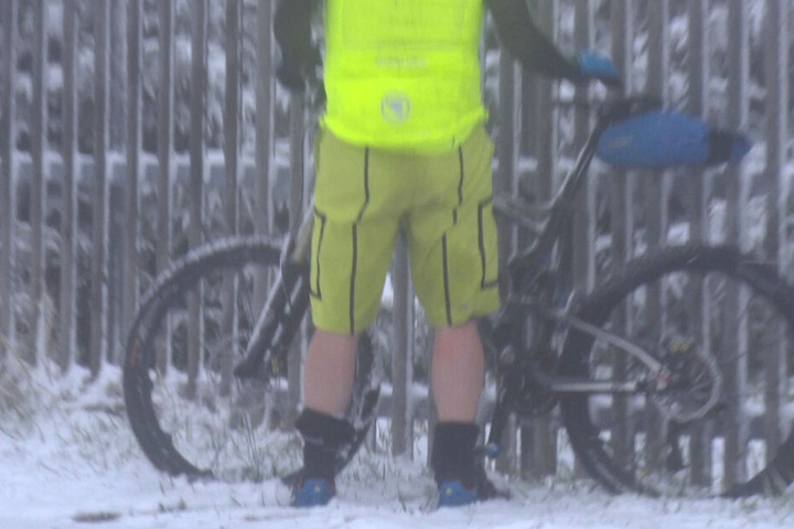 Vom Schnee überraschter Radfahrer.