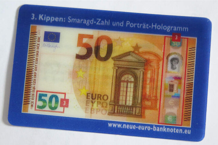 Diese Wechselbild-Karte zeigt die Sicherheitsmerkmale "Smaragdzahl" und "Porträt-Hologramm".