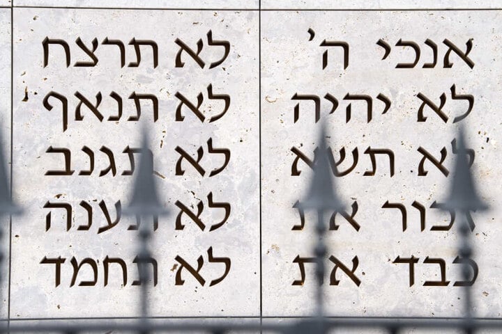 Ein Zaun steht in Stuttgart vor der Synagoge der Israelitischen Religionsgemeinschaft, auf deren Wand im Hintergrund die ersten Worte der zehn Gebote in hebräisch geschrieben sind.
