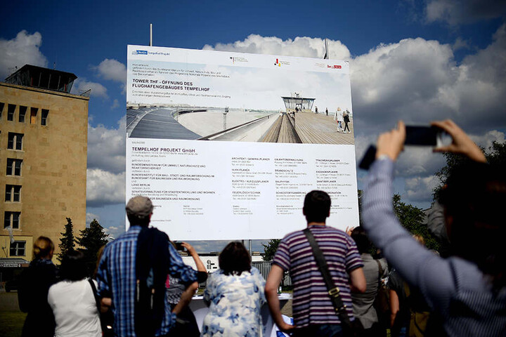 Das Baustellenschild für das Projekt "Tower THF" wird enthüllt und informiert über die angehenden Baumaßnahmen.