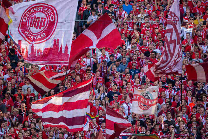 Die Fans vom FC Bayern München schwingen Fahnen.