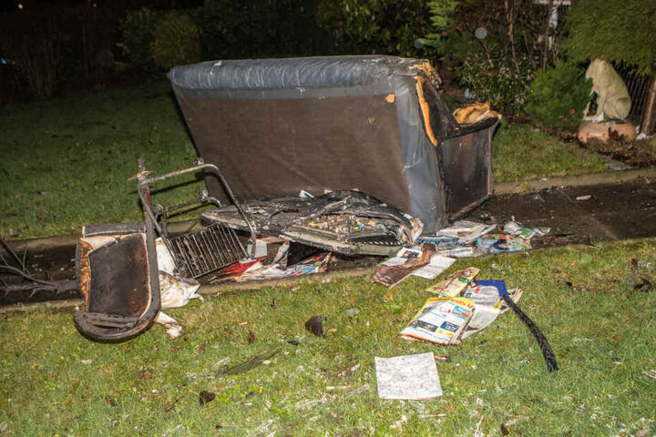 Ein verbranntes Sofa sowie weitere Gegenstände wurden auf den Rasen hinter dem Haus geworfen.