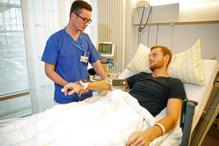 Entlastung des Pflegepersonals: Anstatt selbst aller fünf Minuten die
Vitalfunktionen zu messen, hat Pfleger Lukas Großmann (24) Patient Fabian (26)
die Überwachungs-Manschette angelegt, welche das übernimmt.