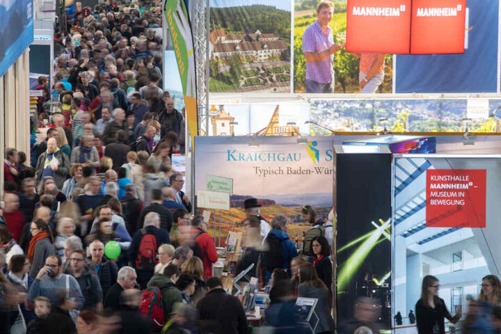 Besucher gehen am ersten Tag der Reisemesse CMT durch eine Halle der Messe Stuttgart.