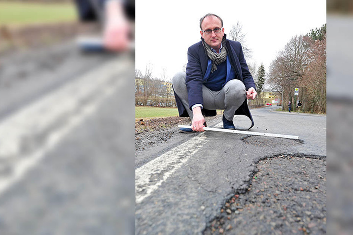 Jörg Vieweg (47, SPD) misst die Schlaglöcher auf der Unritzstraße in Rabenstein.
