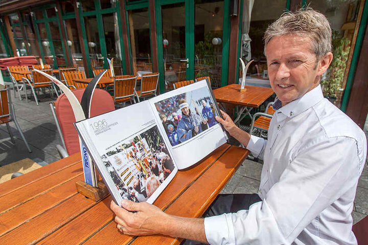 Der ehemalige Skipringer Jens Weißflog blättert in seinem Buch "Bilder meines Lebens".