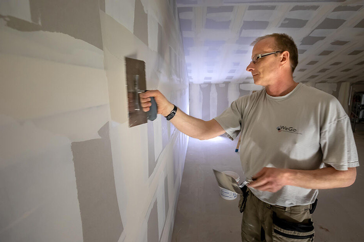 Trockenbauer Ralf Mehner (47) verspachtelt eine Wand in künftigen Lagerräumen.