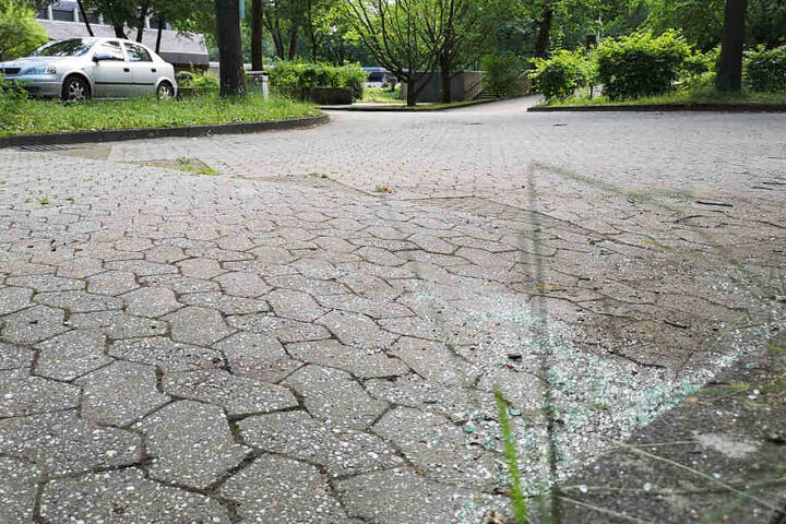 Glasscherben liegen auf einem Parkplatz eines Friedhofes. Hier ereignete sich im Juni 2019 die Tat.