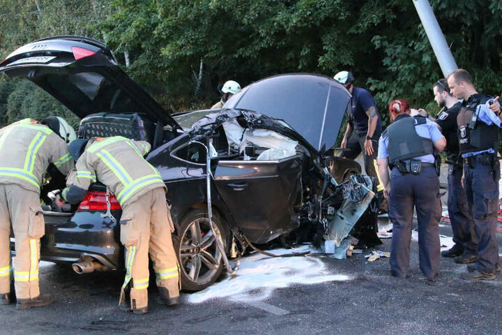 Polizei und Feuerwehr betrachten den Wagen.