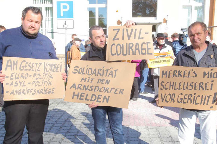 Marco Wruck (links, NPD) hat sich vor dem Kamenzer Gericht mit Schildern postiert.