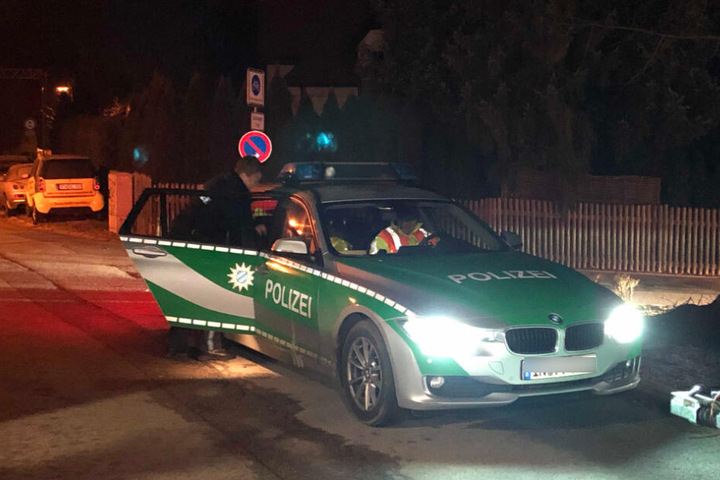 Polizisten stehen auf der Straße vor dem Tatort in Starnberg.