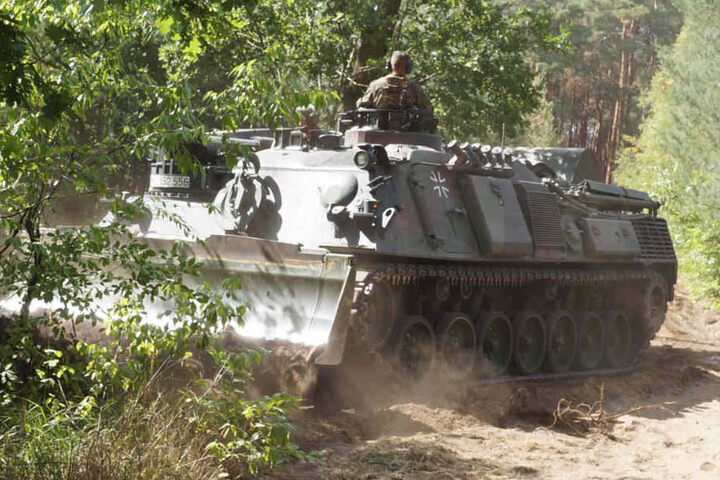 Damit die Feuerwehrleute besser an die Glutnester herankommen, schneidet ein Panzer der Bundeswehr eine Schneise in den Wald.