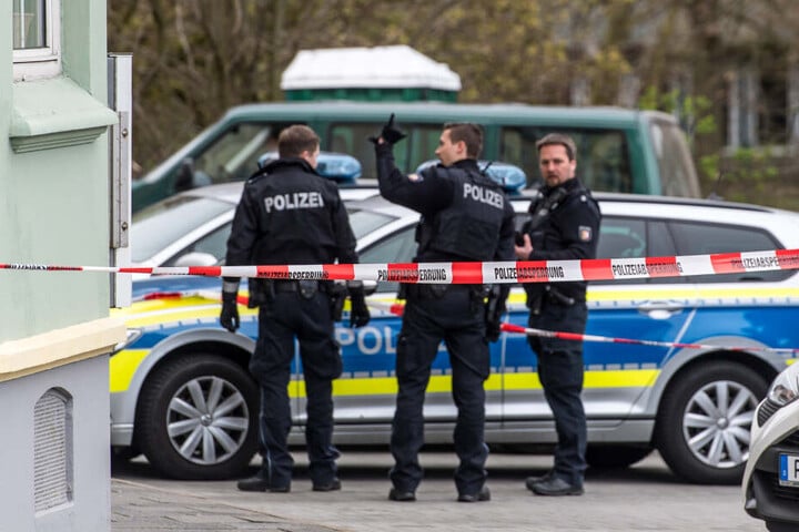 Polizeibeamte stehen vor einem Gebäude in Flensburg, in dem die tote Frau entdeckt wurde. (Archivbild)