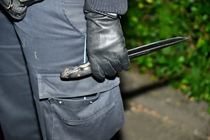 Ein Polizeibeamter hält das Messer des Tatverdächtigen in der Hand.