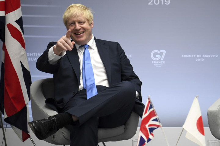 Boris Johnson breit grinsend beim G7 Gipfel.