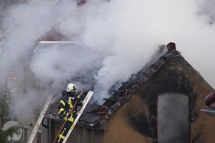 Ein Feuerwehrmann bekämpfte auf dem Schuppendach das Feuer.
