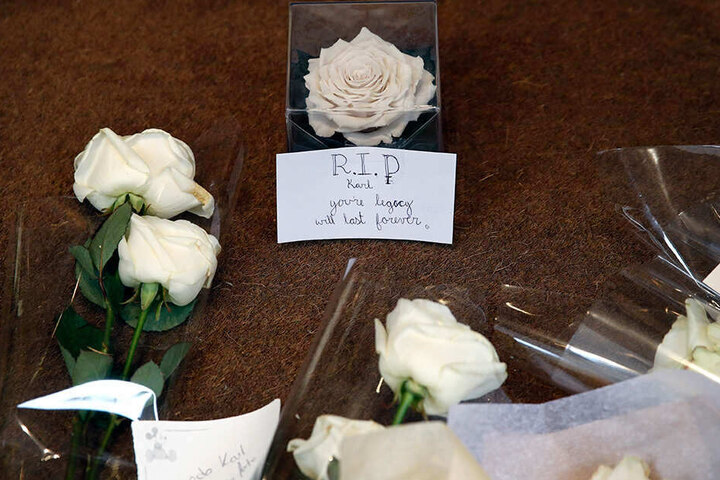 Blumen und ein Zettel liegen am Eingang der Chanel-Zentrale in Paris. Sie wurden von Passanten dort abgelegt, um dem verstorbenen Modeschöpfer Karl Lagerfeld zu gedenken.