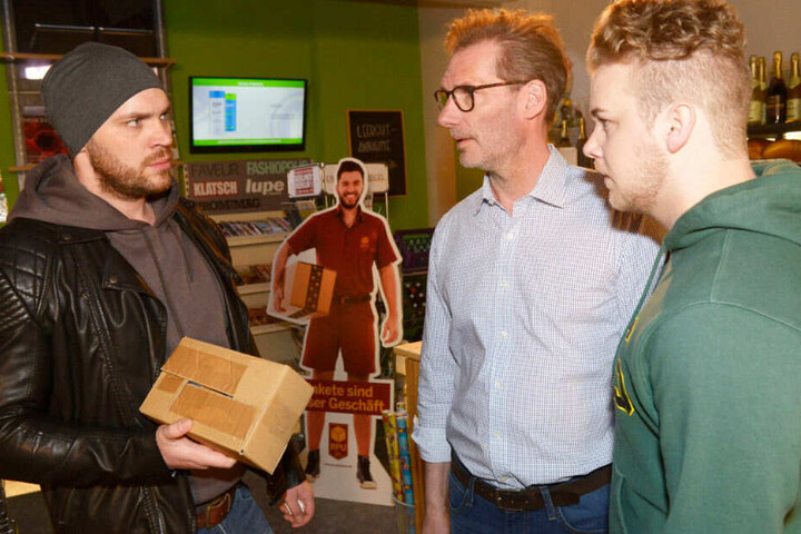 Eric übergibt Alex und Jonas das Paket.