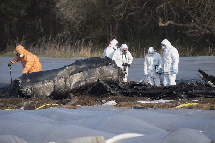 Einsatzkräfte untersuchen das Flugzeug-Wrack am Absturzort.