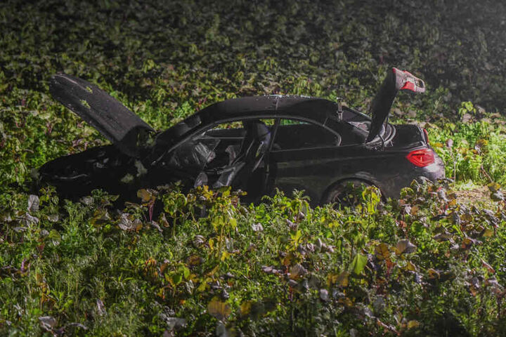 Das Unfallauto steht auf einem Feld.