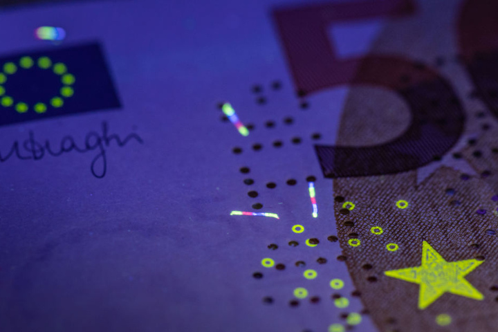 Unter einer UV-Lampe werden in der Zentrale der Deutschen Bundesbank die in das Papier einer echten 50-Euro-Banknote eingearbeiteten Sicherheitsfasern mehrfarbig zum Leuchten gebracht. (Symbolbild)