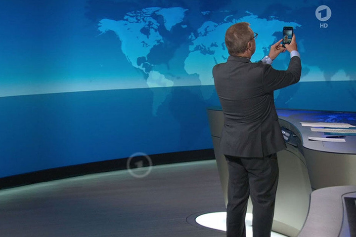 Das Standbild von der ARD zeigt Sprecher Jan Hofer mit einem Smartphone in der Hand.