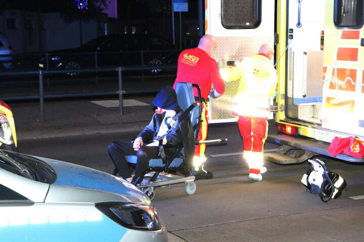 Ein Verletzter wird von Notfallsanitätern in ein Einsatzfahrzeug geladen.
