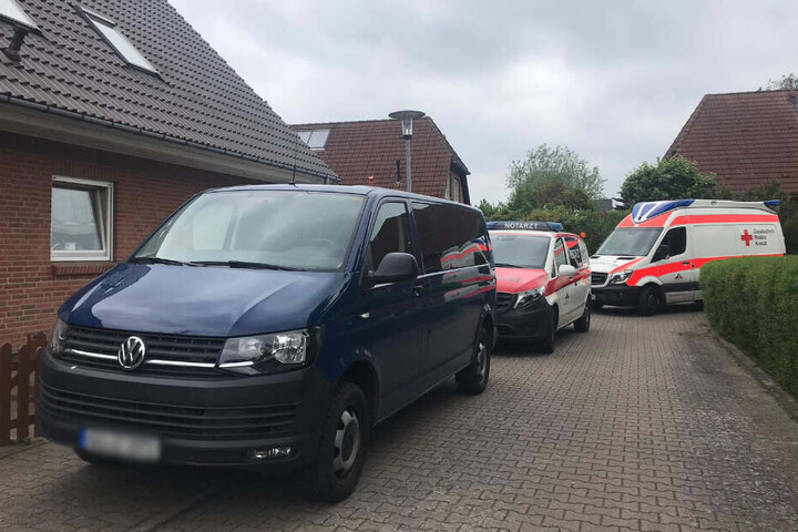 Vor dem Mehrfamilienhaus der Mutter stehen Polizei-, Rettungs- und ein Notarztfahrzeug.