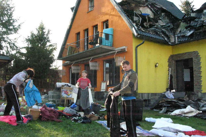 Aufräumen nach der Brandkatastrophe: Sergey (46), Natalie (43) und Sohn Philipp (13) lüften ihre verqualmte Kleidung.